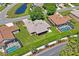 Aerial view of the property with a screened-in pool, lush landscaping, and a well-manicured lawn at 9398 N Burnam Dr, Weeki Wachee, FL 34613