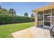 Grassy backyard with a covered patio area featuring ceiling fans for outdoor comfort at 9398 N Burnam Dr, Weeki Wachee, FL 34613