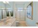 Bright bathroom featuring a single sink vanity, large mirror, and a shower with glass doors at 9398 N Burnam Dr, Weeki Wachee, FL 34613
