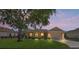 Beautiful home at dusk with well-kept lawn, attached two car garage, and a cozy front porch at 9398 N Burnam Dr, Weeki Wachee, FL 34613