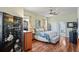 The main bedroom features a ceiling fan, wood floors and a view into the main bathroom at 9398 N Burnam Dr, Weeki Wachee, FL 34613