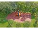 Aerial view of a colorful community playground with swings and climbing structures, nestled among trees and greenery at 9398 N Burnam Dr, Weeki Wachee, FL 34613