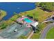 An aerial view of a refreshing community pool and tennis courts next to a serene lake at 9398 N Burnam Dr, Weeki Wachee, FL 34613