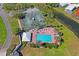 Aerial view of the community pool and tennis courts surrounded by lush landscaping and waterways at 9398 N Burnam Dr, Weeki Wachee, FL 34613
