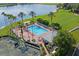 Aerial view of a community pool, spa, and tennis courts surrounded by palm trees and lush greenery at 9398 N Burnam Dr, Weeki Wachee, FL 34613