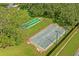 Aerial shot of shuffleboard and bocce ball courts surrounded by lush green landscaping and mature trees at 9398 N Burnam Dr, Weeki Wachee, FL 34613