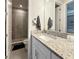Bathroom vanity featuring granite countertop, white cabinets, and a walk-in shower at 946 Highland Ave # 47, Dunedin, FL 34698