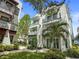 Exterior shot of condo featuring white facade, balconies and lush tropical landscaping at 946 Highland Ave # 47, Dunedin, FL 34698