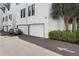 Street view of townhome garages, landscaping, and a parked car at 946 Highland Ave # 47, Dunedin, FL 34698