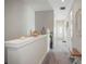 Light-filled hallway featuring neutral walls, carpet flooring, and decorative elements, leading to various rooms at 946 Highland Ave # 47, Dunedin, FL 34698
