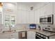 Contemporary kitchen with white cabinetry, stainless steel appliances, and light-colored countertops at 946 Highland Ave # 47, Dunedin, FL 34698