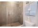 Glass-enclosed shower features gray tile and modern fixtures at 946 Highland Ave # 47, Dunedin, FL 34698