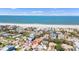 A high angle shot of beach houses, with a view of blue ocean water and a beautiful sandy beach on a sunny day at 1008 Mandalay Ave, Clearwater, FL 33767