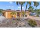 Charming single-story home with a terra cotta roof, stucco exterior, and a well-manicured yard with tropical landscaping at 1008 Mandalay Ave, Clearwater, FL 33767