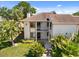 Exterior view of the condo featuring a private balcony and lush, tropical landscaping at 108 Lakeview Ct # 108, Oldsmar, FL 34677