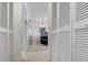 Hallway lined with closet doors that opens to a dining area with pendant lighting and bar seating at 108 Lakeview Ct # 108, Oldsmar, FL 34677