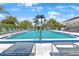 Relax in the sun at this expansive pool, surrounded by comfortable loungers and tropical trees at 108 Lakeview Ct # 108, Oldsmar, FL 34677