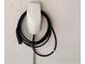 Tesla electric vehicle charger installed on a clean, white wall with visible cord at 11118 Running Pine Dr, Riverview, FL 33569