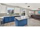 Bright open kitchen boasts blue cabinets, quartz countertops, and stainless steel appliances with access to screened pool at 11118 Running Pine Dr, Riverview, FL 33569