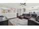 Open-concept living room features a dark leather sectional, dark hardwood floors, and gray walls at 11118 Running Pine Dr, Riverview, FL 33569