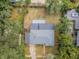 An aerial view of the home showing the roof, yard, shed, and surrounding foliage at 1205 E Hamilton Ave, Tampa, FL 33604