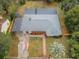 High-angle aerial view of the home, displaying the yard, roofing, and nearby tree coverage at 1205 E Hamilton Ave, Tampa, FL 33604