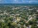 Expansive aerial view showcases a lush, green neighborhood with mature trees and charming homes under a partly cloudy sky at 1205 E Hamilton Ave, Tampa, FL 33604