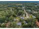 A high aerial view of a neighborhood shows lush greenery, mature trees, and tidy homes on a partly cloudy day at 1205 E Hamilton Ave, Tampa, FL 33604