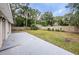 Large backyard with a lush lawn, privacy fence, and mature trees at 1205 E Hamilton Ave, Tampa, FL 33604