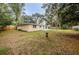 A view of the backyard with a house, grass, trees, and a bird bath at 1205 E Hamilton Ave, Tampa, FL 33604