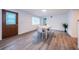 Bright dining area boasting a brown door, a window with blinds, and modern flooring at 1205 E Hamilton Ave, Tampa, FL 33604