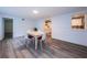 Open dining room featuring gray flooring, white walls with wainscoting, and a wooden table at 1205 E Hamilton Ave, Tampa, FL 33604