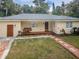 A single-story home is enhanced by the brick pathway and quaint porch swing at 1205 E Hamilton Ave, Tampa, FL 33604