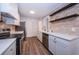 Bright kitchen boasts stainless steel appliances, white cabinetry, and wood-look floors at 1205 E Hamilton Ave, Tampa, FL 33604