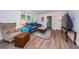 Bright living room featuring wood style floors, a cozy blue sofa, and natural light from the windows at 1205 E Hamilton Ave, Tampa, FL 33604
