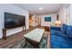 Bright living room with modern hardwood style floors, a large television, and comfortable furniture at 1205 E Hamilton Ave, Tampa, FL 33604