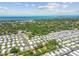 An aerial view of a charming residential neighborhood near the ocean, surrounded by lush green trees and blue skies at 1219 Michigan N Dr, Dunedin, FL 34698