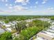 Overhead view showing a residential neighborhood with green trees and some water in the horizon at 1219 Michigan N Dr, Dunedin, FL 34698