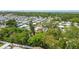 Arial image showing a neighborhood with trees and a partial view of the coast in the background at 1219 Michigan N Dr, Dunedin, FL 34698