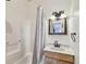 Bathroom with a shower, bathtub, and vanity with a decorative light fixture at 1219 Michigan N Dr, Dunedin, FL 34698