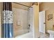 Neutral full bathroom features a tub with shower, decorative tile, and adjacent half bath at 1219 Michigan N Dr, Dunedin, FL 34698