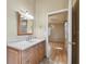 Well-lit bathroom featuring a vanity with drawers and a doorway leading to a bedroom with wood floors at 1219 Michigan N Dr, Dunedin, FL 34698