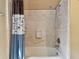 Bright bathroom featuring a tiled shower/tub combination with shower curtain and grab bar for safety at 1219 Michigan N Dr, Dunedin, FL 34698
