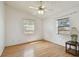 Clean and minimal bedroom with wood laminate flooring, ceiling fan and natural light from two windows at 1219 Michigan N Dr, Dunedin, FL 34698
