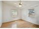 Clean and minimal bedroom with wood laminate flooring, ceiling fan and natural light from two windows at 1219 Michigan N Dr, Dunedin, FL 34698