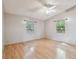 Bright bedroom with hardwood floors, two windows, a ceiling fan, and neutral walls at 1219 Michigan N Dr, Dunedin, FL 34698