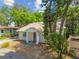 Exterior of the home showing the front facade with trees, yard, and concrete driveway at 1219 Michigan N Dr, Dunedin, FL 34698