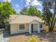 View of home featuring neutral color, brown front door, and well-kept landscaping at 1219 Michigan N Dr, Dunedin, FL 34698