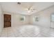 Spacious living room with tile flooring, a ceiling fan, and a dark wood front door at 1219 Michigan N Dr, Dunedin, FL 34698