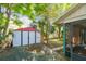View of the backyard shed area amidst lush greenery and trees, offering ample outdoor storage at 1219 Michigan N Dr, Dunedin, FL 34698